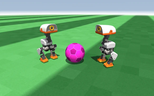 Two Microduck robots standing on the pitch beside the ball